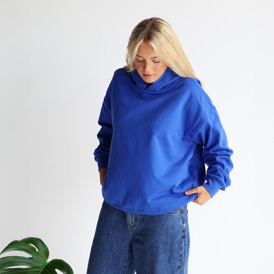 Woman standing wearing blue hoodie