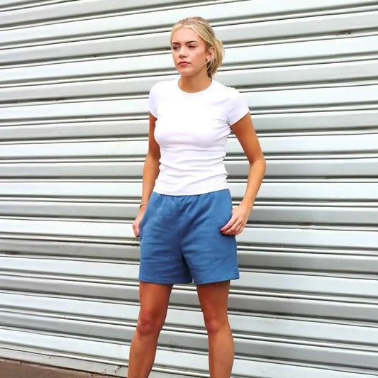 Woman standing wearing blue shorts